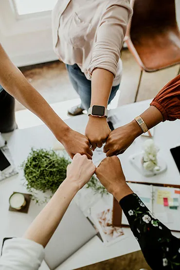 Imagen que muestra varias manos unidas, representando a diferentes personas trabajando juntas, simbolizando así la importancia del trabajo en equipo.